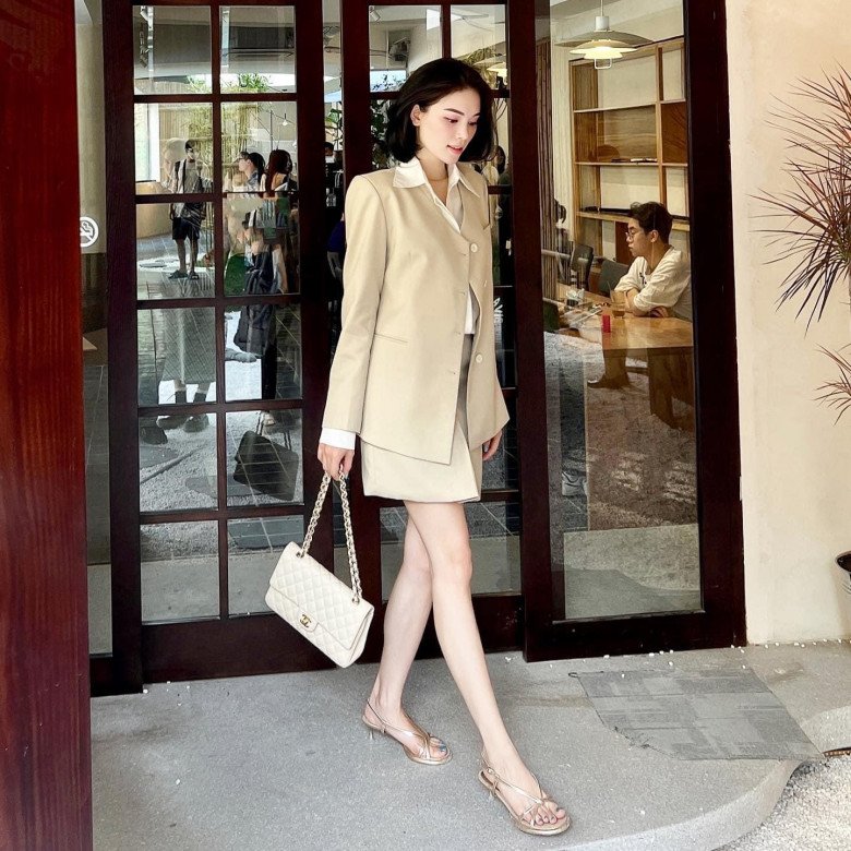 Trang phục công sở tông màu be được phối sandals ánh kim và túi Chanel, tạo nên tổng thể tươi trẻ mà vẫn thanh lịch.