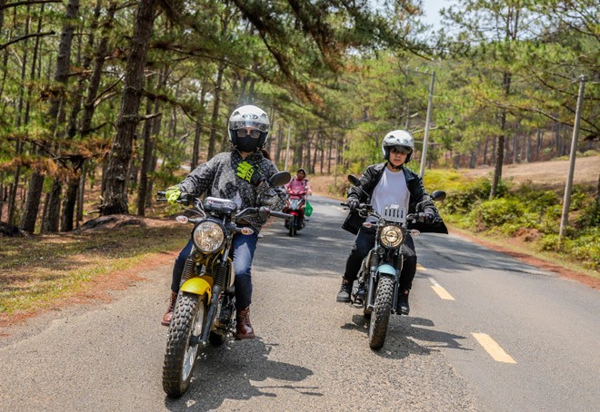 Huy and his mother posing with their motorcycles