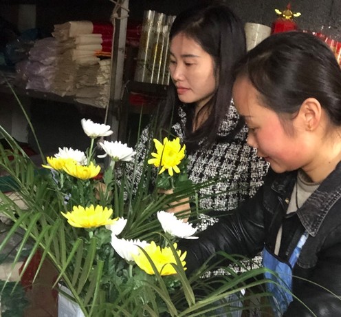 Yang Niuhua đã mua một bó hoa cúc cho cha mẹ mình và chuẩn bị bày tỏ lòng thành kính đối với họ.