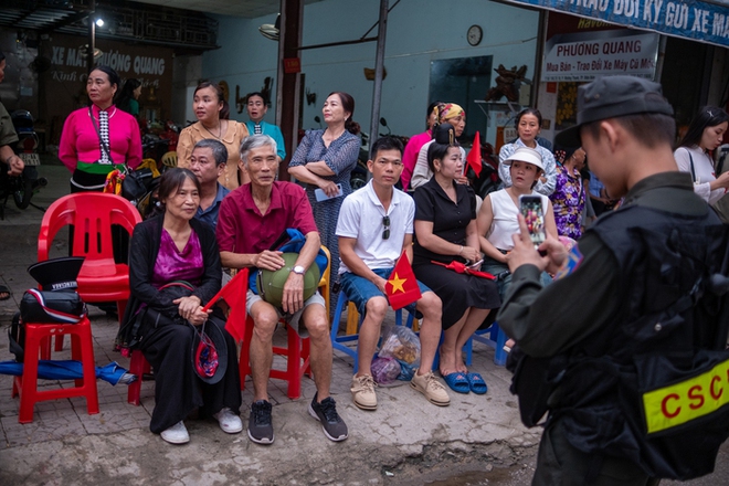 Một
đồng chí CSCĐ tranh thủ chụp ảnh ghi lại khoảnh khắc kỉ niệm đáng
nhớ cho người dân ngồi bên đường