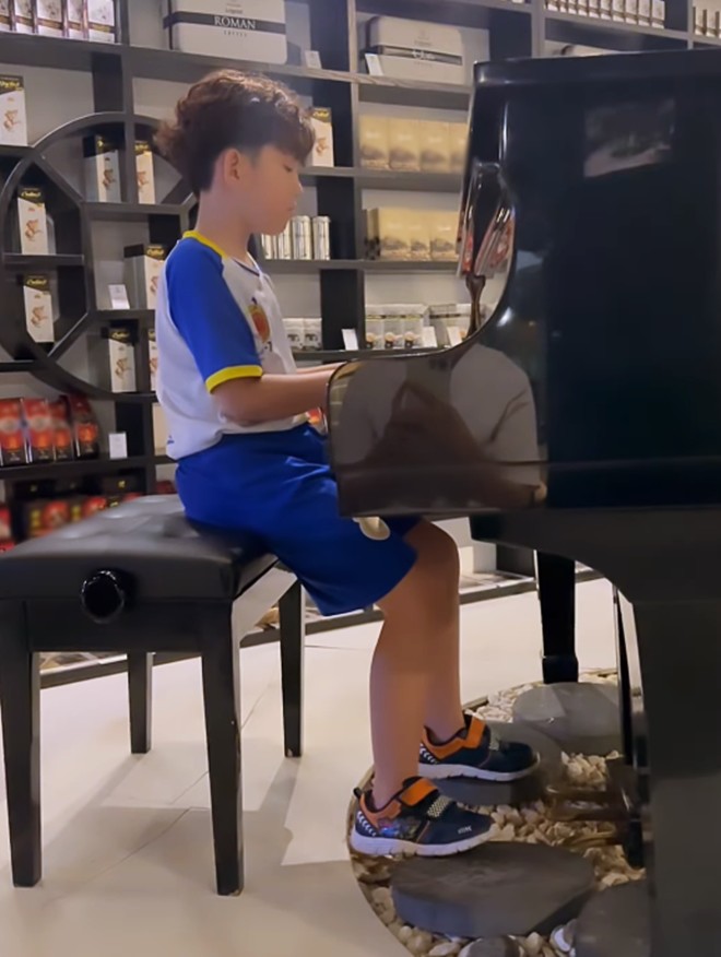 Cậu bé vô cùng chăm chú với những phím đàn.