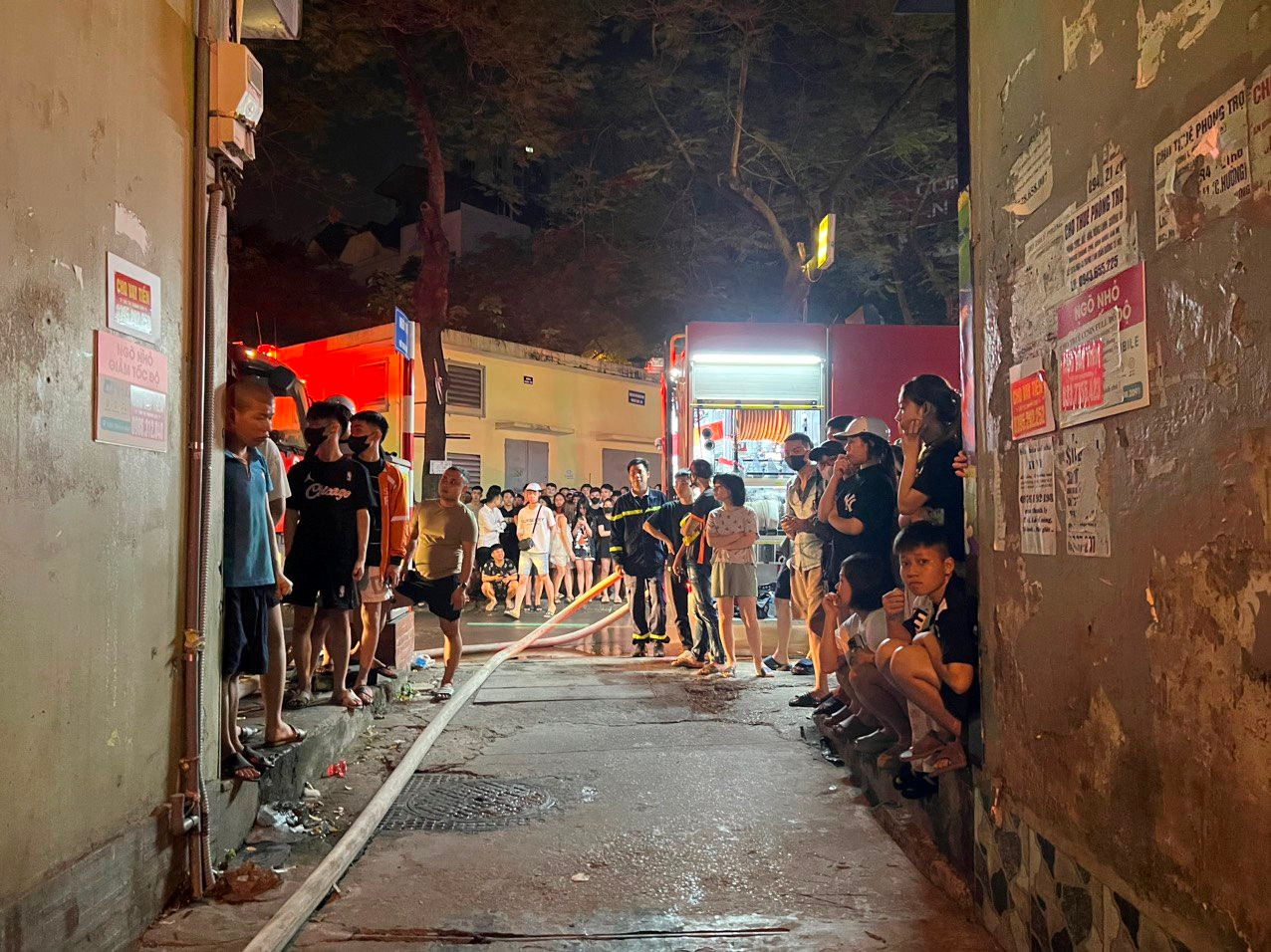 Tuy nhiên do ngôi nhà nằm sâu trong ngõ nhỏ rộng chưa đến 2m, cách xa mặt đường Trung Kính hơn 200m nên xe cứu hỏa không thể tiếp cận tận nơi. Lực lượng cứu nạn cứu hộ phải kéo đường ống dẫn nước từ đường Trung Kính vào hiện trường để chữa cháy - Ảnh: Đại đoàn kết