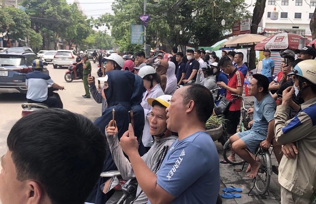 Người dân hiếu kỳ đứng xem lực lượng chức năng xử lý người đàn ông say rượu đập phá tài sản. Ảnh: MXH