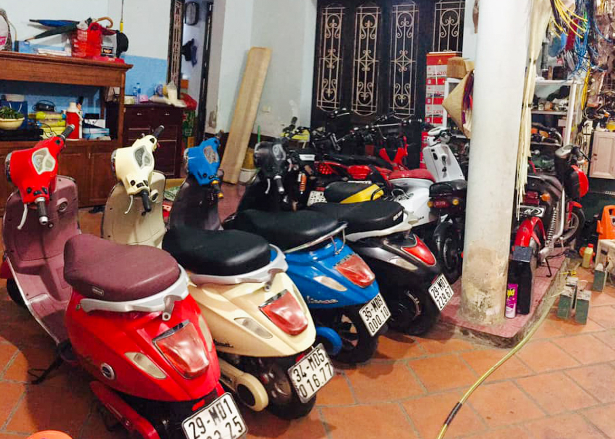 Xe máy xếp thành hàng trên sân, trước nhà gia chủ.