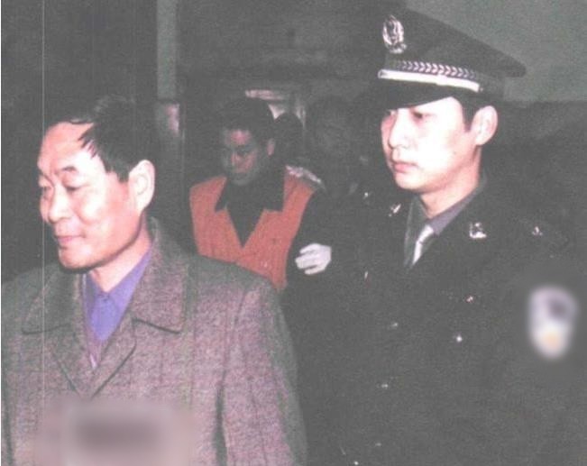 Chu Kỳ Đông bị cảnh sát dẫn giải ra tòa năm 2002, theo sau là Triệu Chinh Hòa. Ảnh: 163