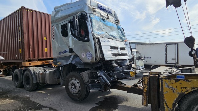 Xe container hư hỏng phần đầu được xe cứu hộ di dời khỏi hiện trường.