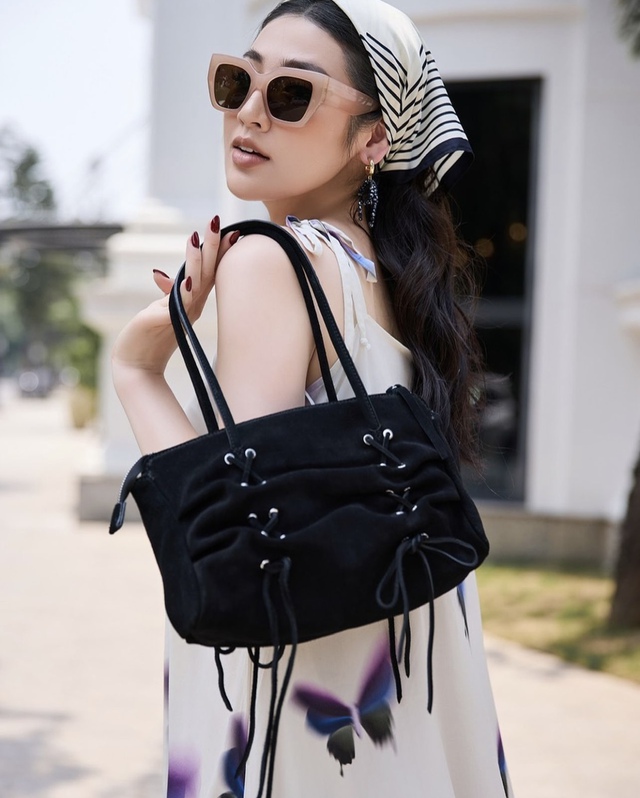 Chiếc túi sách màu đen vừa tương phản, vừa đồng điệu với tổng thể outfit.