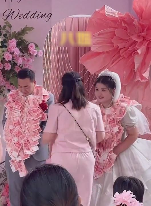 Chị gái thứ 8 của chú rể lên trao quà cho cặp đôi.