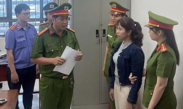 Bị can Nguyễn Thị Ngọc Lan nghe công an tống đạt Quyết định khởi tố, Lệnh bắt tạm giam. (Ảnh: Công an Bình Thuận).