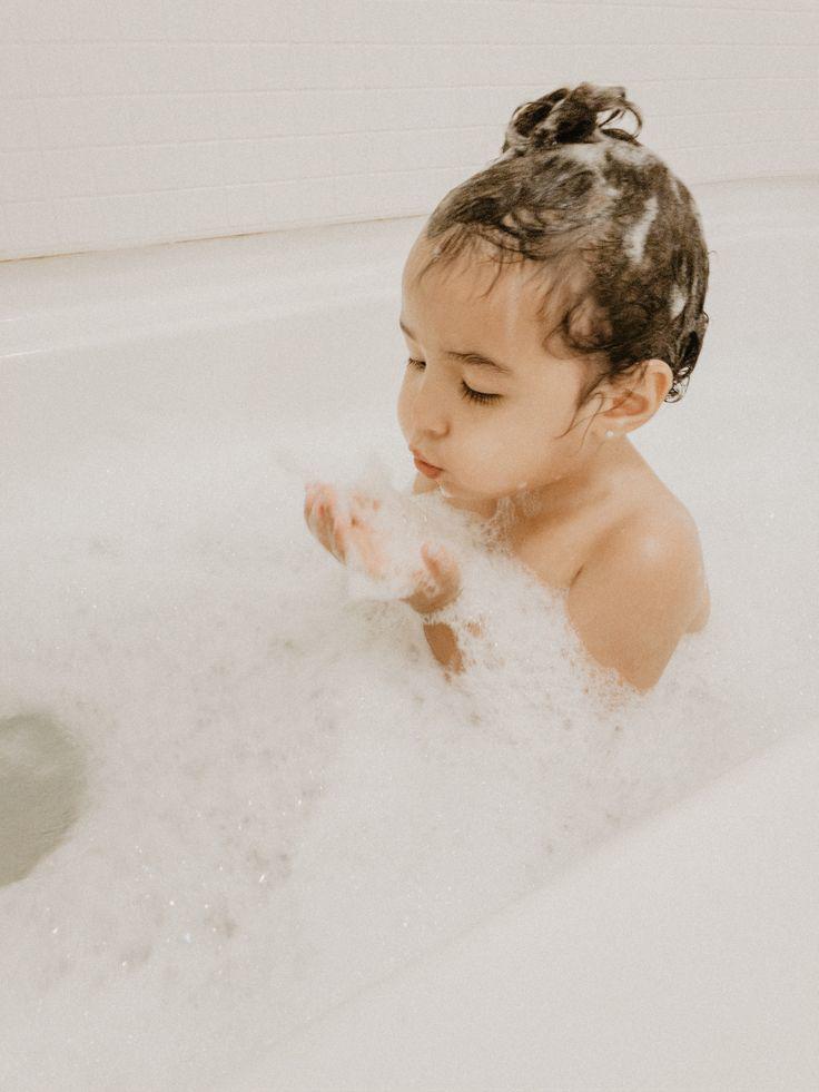 Baby shampoo bottle and a mother gently washing her baby