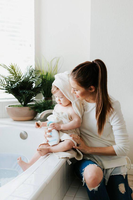 Baby body wash bottle and a mother gently washing her baby