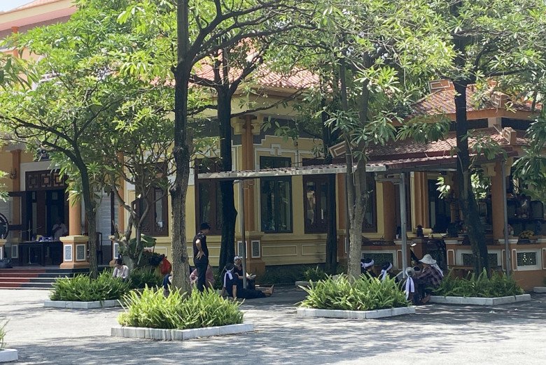 Người thân của các nạn nhân trong vụ cháy ở phố Định Công Hạ ngồi chờ nhận tro cốt tại nghĩa trang Văn Điển, trưa 17/6. Ảnh: Minh Vy