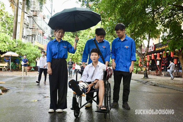 Hà Nội: Thí sinh bị gãy chân vừa mổ cấp cứu được sinh viên tình nguyện đưa vào phòng thi - 1