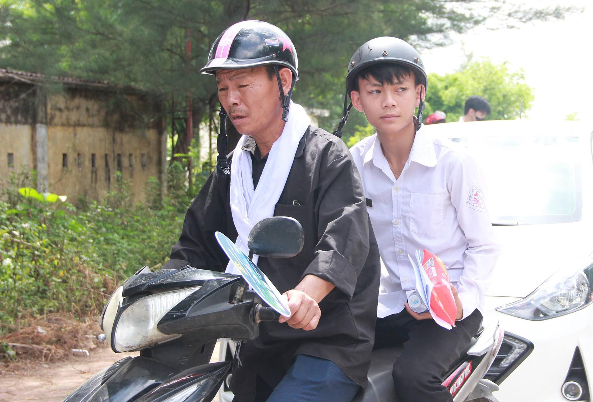 Ông Dụng nén nỗi đau mất vợ, chở con đến điểm thi. Ảnh: TH