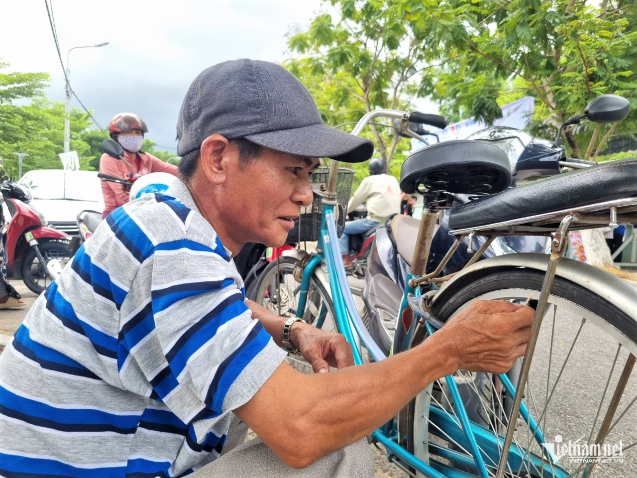 Kiểm ra chiếc xe để đảm bảo không bị hư hỏng khi đưa con đi thi. Ảnh: Hồ Giáp