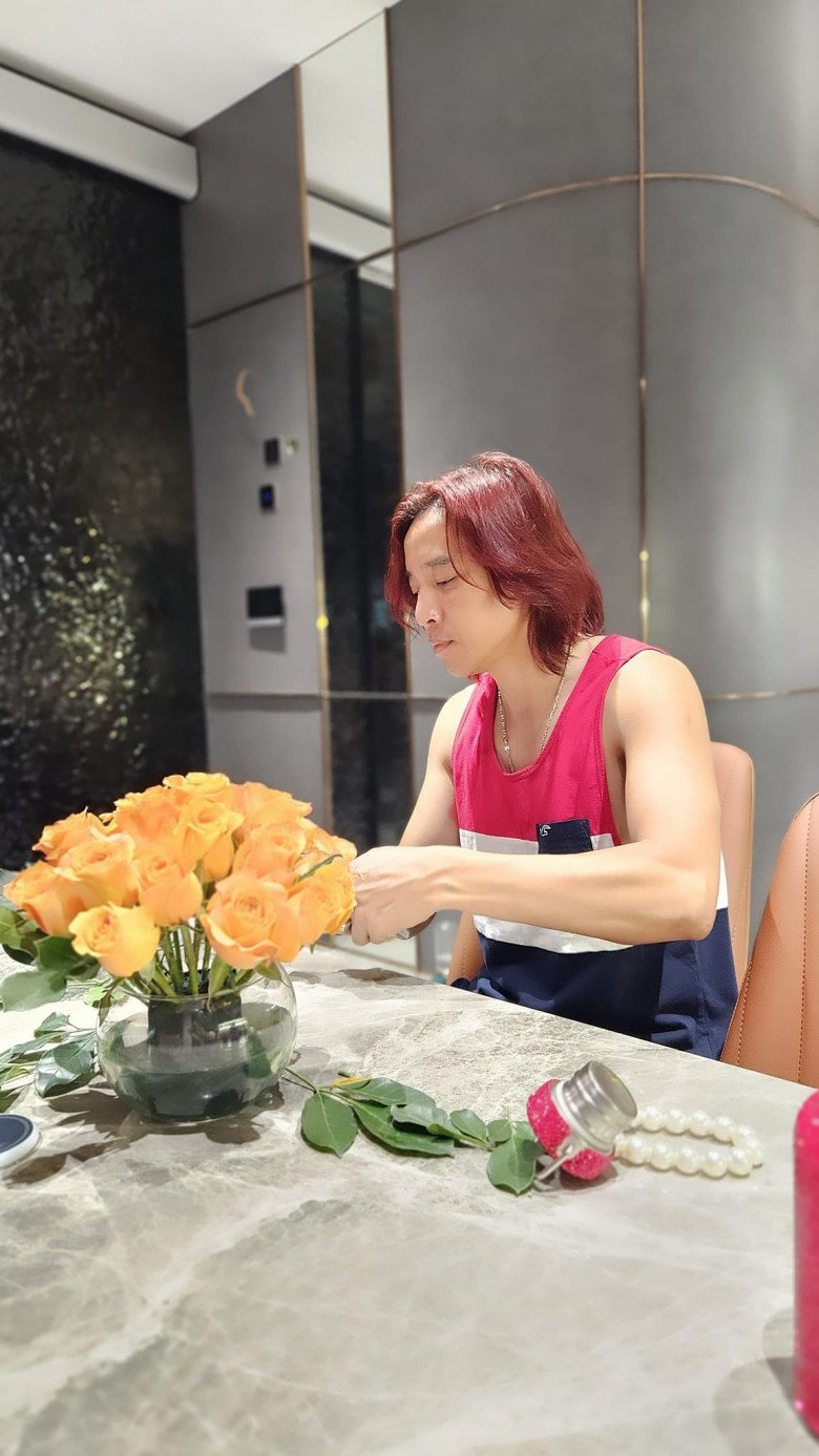 Đây chính là anh thợ cứng cắm hoa cho nhà Việt Hương. Bố bé Elyza cẩn thận cắm những bông hồng màu cam rực rỡ vào một chiếc bình thủy tinh tròn thấp, trông rất xinh xắn.