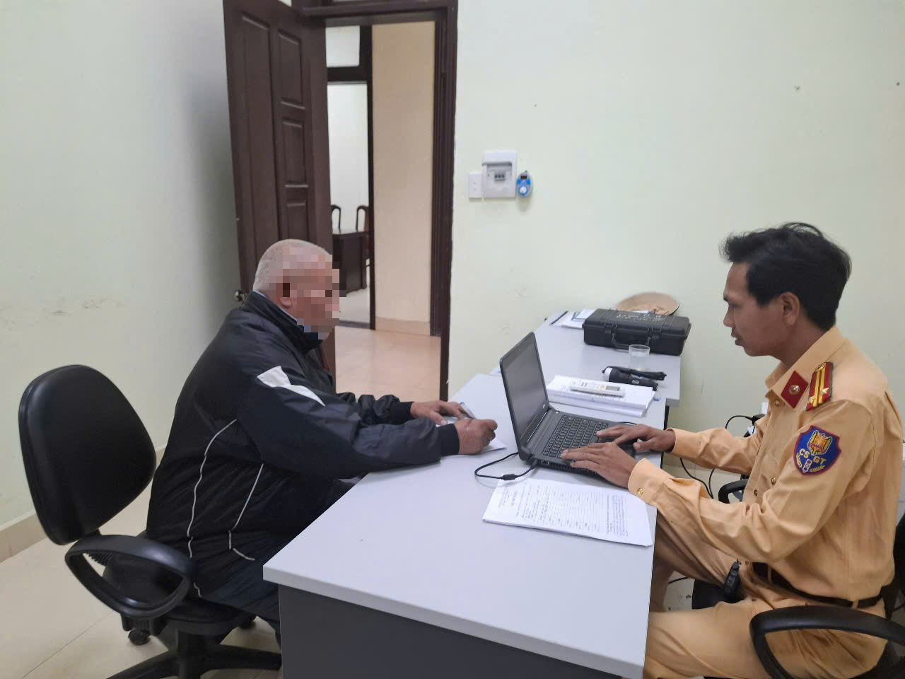 Ông Q. làm việc với công an sau khi cố tình tông gãy rào chắn đường sắt.