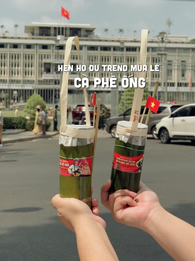 Du khách cầm ly cà phê ống tre check in Dinh Độc Lập. Ảnh: Saigondidau