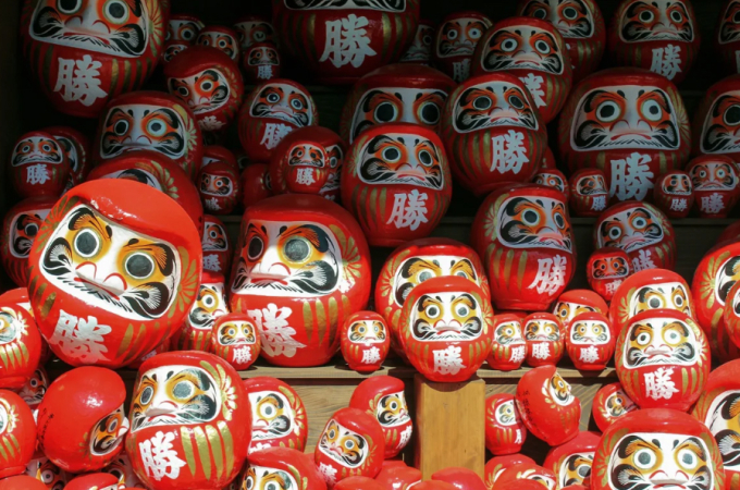 Búp bê daruma có hình tròn, màu đỏ rực rỡ và hai mắt mở to. Ảnh: CNN