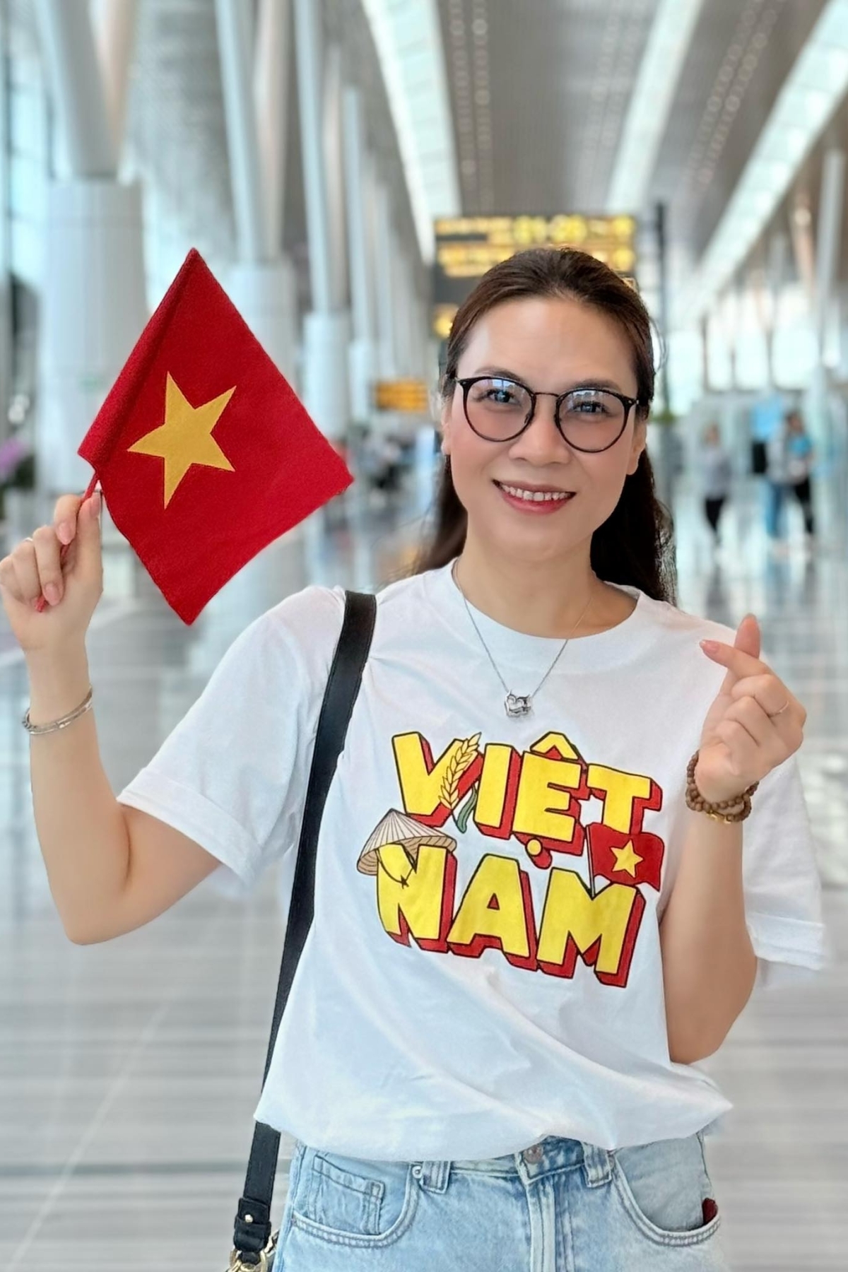 Ca sĩ Mỹ Tâm thể hiện niềm tự hào dân tộc khi mặc áo in hai chữ Việt Nam và cầm theo cờ Tổ quốc.