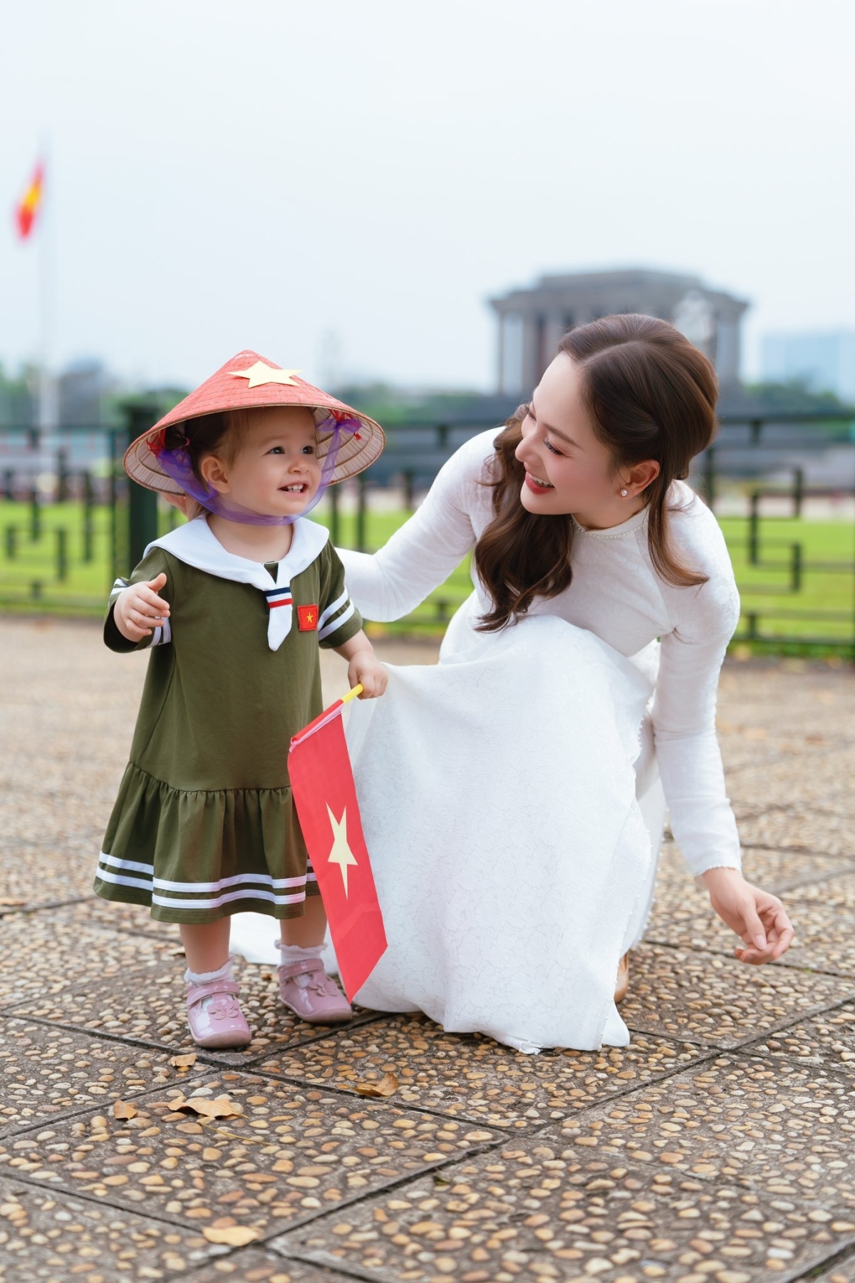 Tại Hà Nội, diễn viên Lan Phương đưa con gái hơn một tuổi thăm Lăng Bác. Em bé Mia cười rạng rỡ khi được mẹ cho đội nón lá, mặc áo in cờ đỏ sao vàng và cầm tờ Tổ quốc.