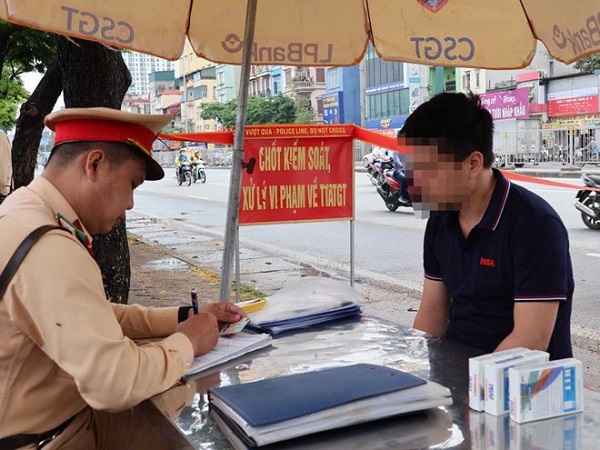 CSGT xử lý tài xế xe khách vi phạm gần khu vực bến xe Giáp Bát (Hà Nội). Ảnh: CAHN