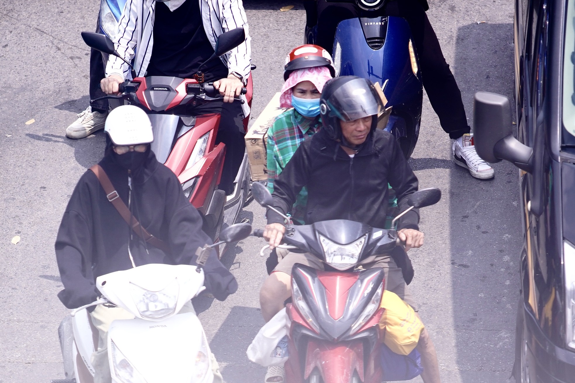 Người phụ nữ dùng khăn lót dưới mũ bảo hiểm để chống chọi với cái nắng nóng.