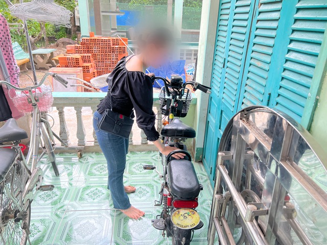 Bà N.T.H (mẹ ruột Tr.) đau lòng khi sờ vào chiếc xe đạp điện của con gái