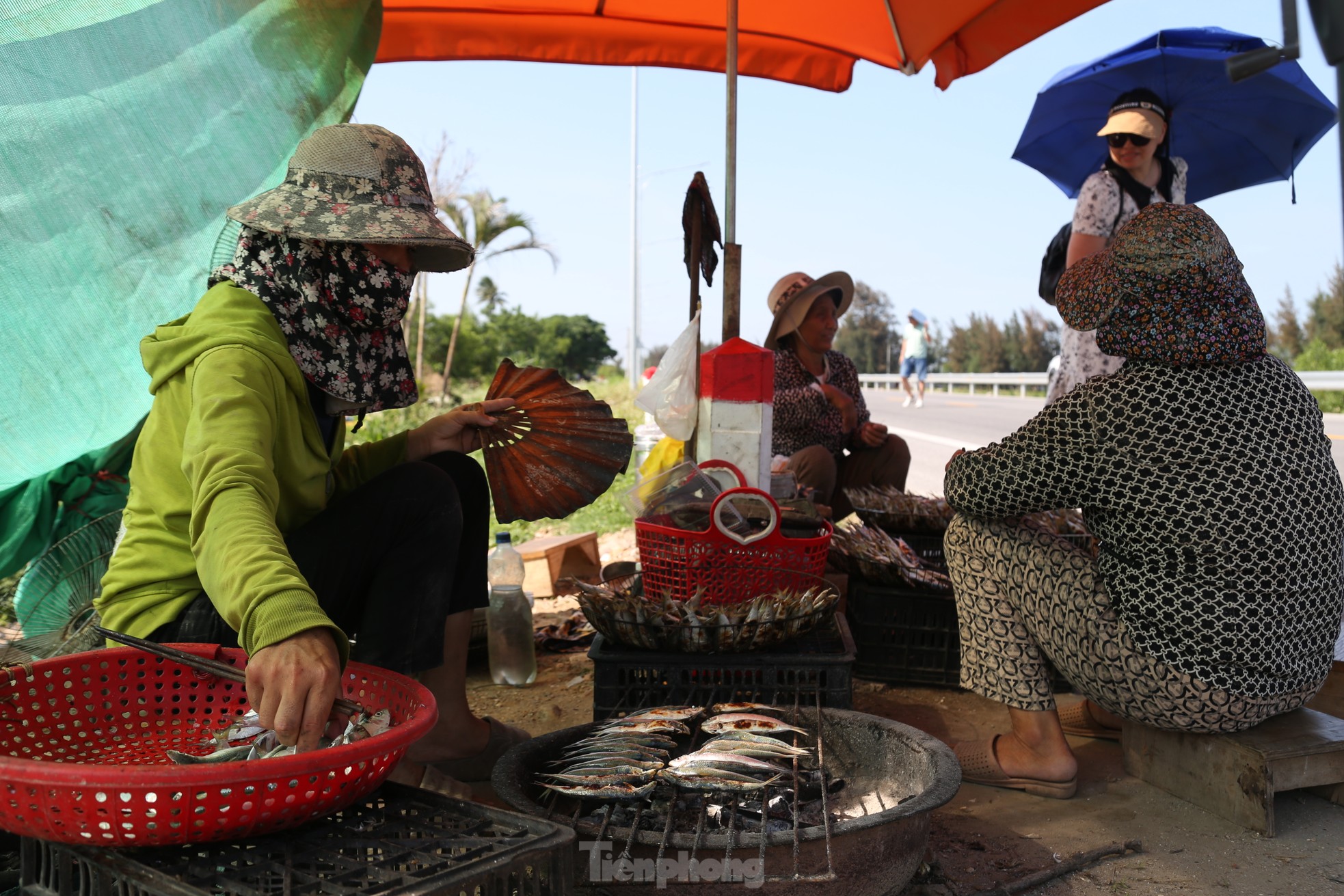 Thương lái nhóm bếp than ngay trước cổng nhà, dọc tuyến đường ven biển để nướng cá bán. Giá cá trích nướng là 40.000 đồng/kg.