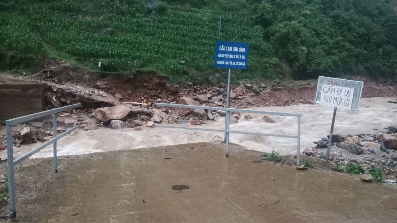 Nước suối đổ về tạo thành dòng lũ lớn khiến trôi cầu tạm tại Lào Cai.