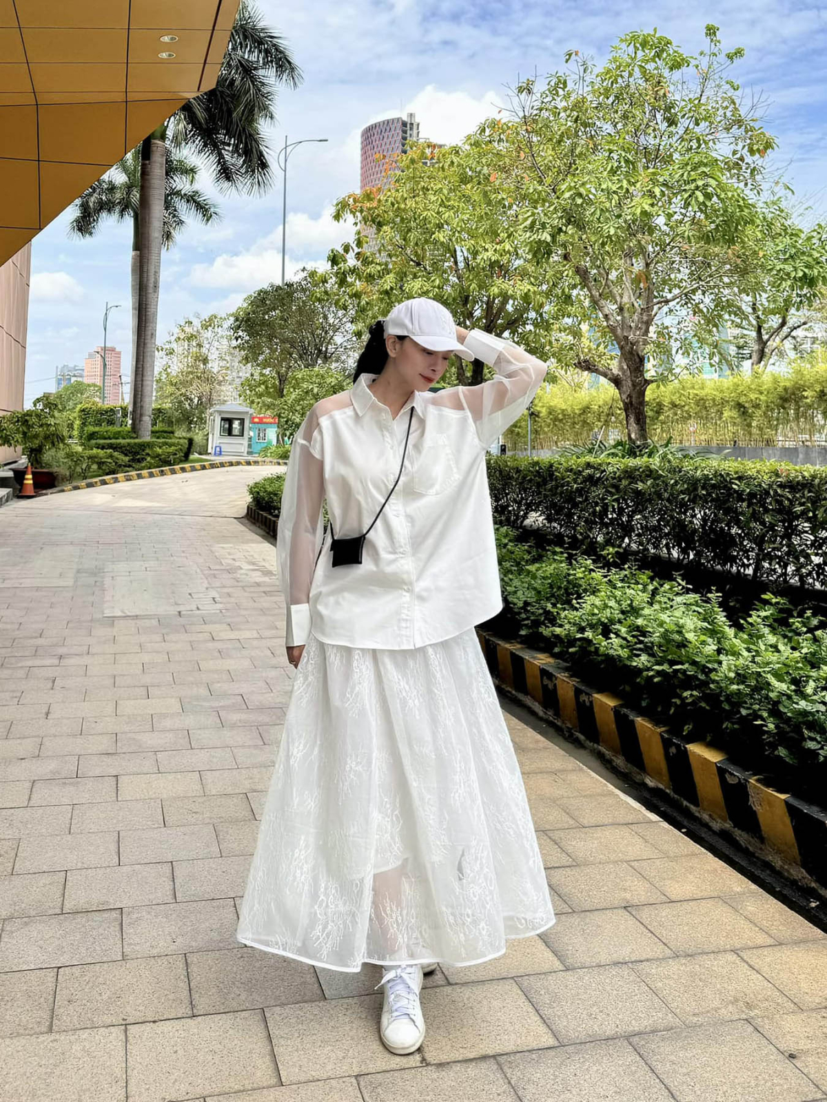 Một lần xuống phố, nữ diễn viên kết hợp sơ mi suông với chân váy maxi xòe, hoàn toàn che đi vòng hai. Cô thường mang giày sneakers hoặc dép bệt để thuận tiện di chuyển.