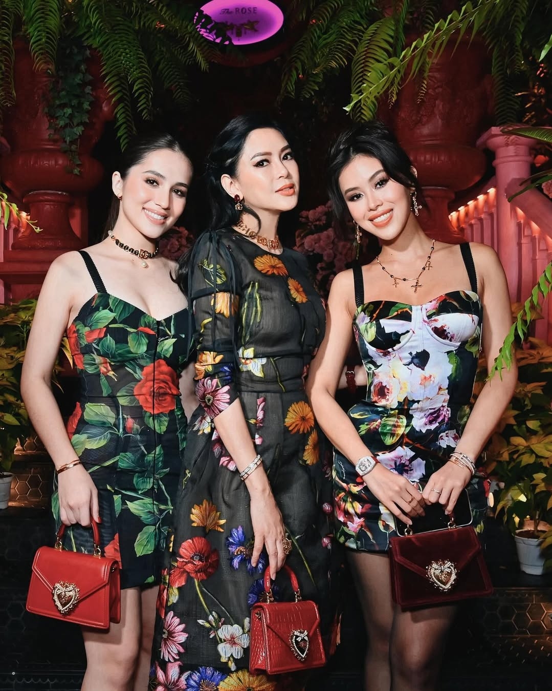 Ba phiên bản dòng Devotion màu đỏ còn tô điểm phong cách cho gia đình hào môn tại bữa tiệc Dolce amp; Gabbana hồi tháng 2/2024. Túi da bê gắn hạt trai của Marie Trâm Anh (trái) tiêu tốn 1.895 USD (khoảng 50 triệu đồng); phụ kiện dập họa tiết da cá sấu trên tay diễn viên Vị đắng tình yêu Thủy Tiên (giữa) có giá 2.695 USD (hơn 70 triệu đồng); còn Tiên Nguyễn khoe túi nhung đính hạt trai 2.145 USD (hơn 56 triệu đồng).