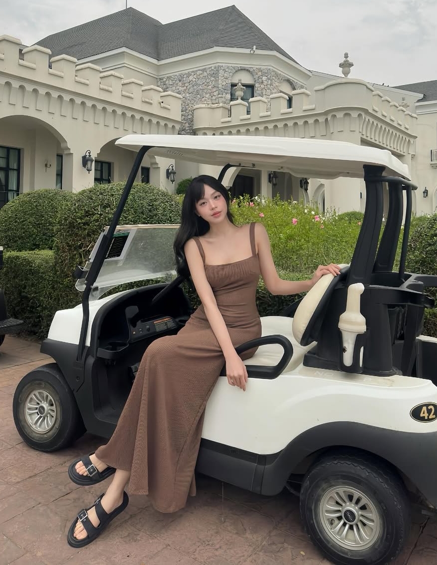 Thiết kế hai dây thịnh hành ở thập niên 1990 là món đồ cơ bản thường có trong tủ đồ của phụ nữ. Chúng được yêu thích vì tiện lợi, có thể mặc suốt bốn mùa với cách phối đa dạng. Là một trong những người chuộng kiểu dáng này, hoa hậu Thanh Thủy chọn váy nâu chất liệu thun co giãn, kết hợp mốt sandals của bố trong một kỳ nghỉ.