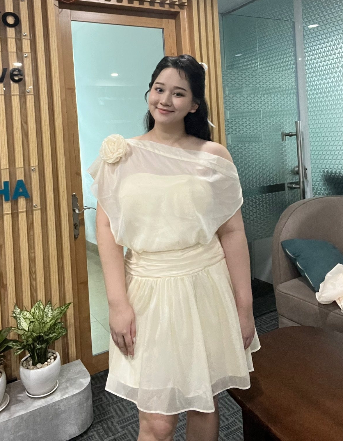 Váy cocktail xuyên thấu lệch vai đính hoa 3D giúp cô tăng vẻ duyên dáng.