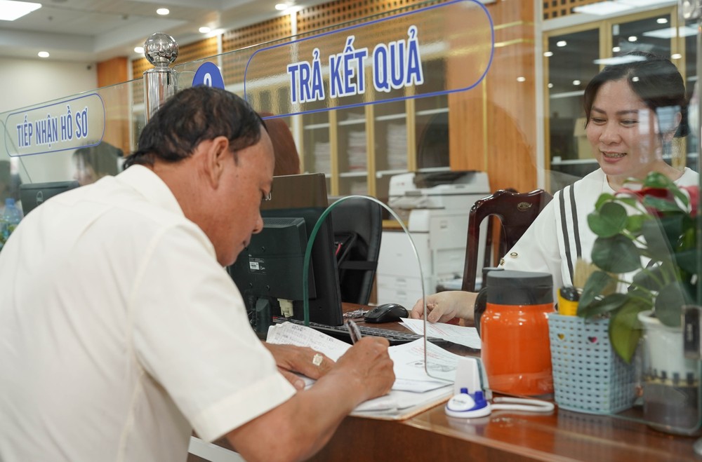 Cán bộ BHXH khu vực XXVII tư vấn cho người dân về chế độ BHXH tại bộ phận một cửa. Ảnh: THUẬN VĂN