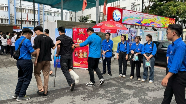 Thí sinh bị gãy chân được đội tình nguyện viên hỗ trợ đưa vào phòng làm thủ tục dự thi tốt nghiệp THPT năm 2024.