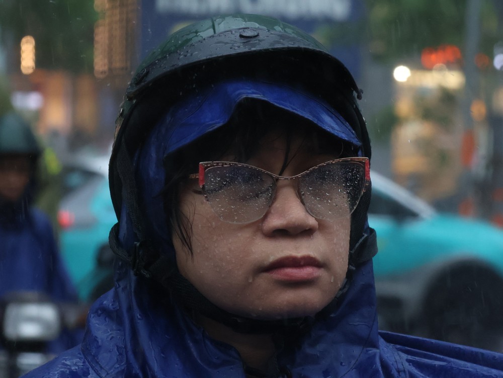 Phụ huynh đứng chờ con thi dưới mưa. Ảnh: LONG VŨ