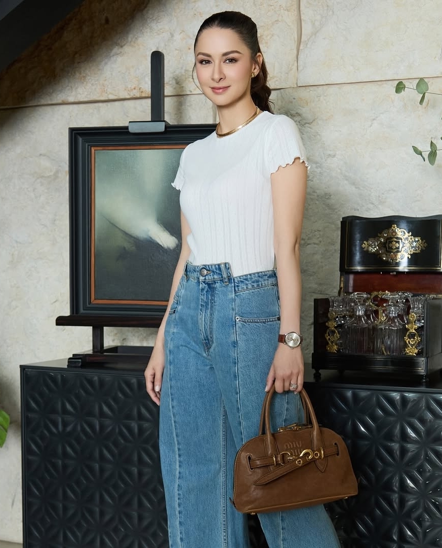 Phong cách sang trọng của ngôi sao 41 tuổi thể hiện qua áo cộc tay dệt kim mỏng, quần jeans bất đối xứng và túi bowling của Miu Miu. Theo Marie Claire, Marian luôn sơ vin áo để tạo vẻ lịch sự, trang nhã. Cô ít khi buông áo ngoài quần vì kiểu mặc này dễ tạo cảm giác luộm thuộm.