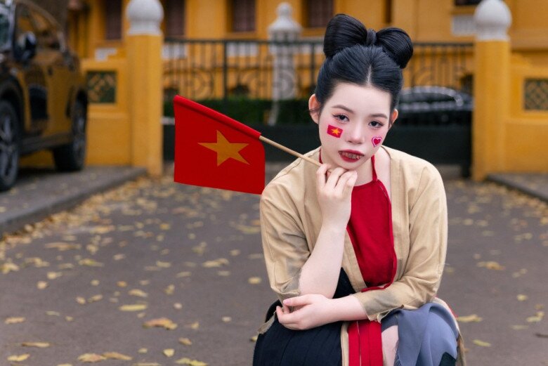 Nữ nghệ sĩ trẻ vẽ trái tim lên má và cờ đỏ sao vàng để tạo vẻ ngoài độc lạ, thu hút mọi ánh nhìn.