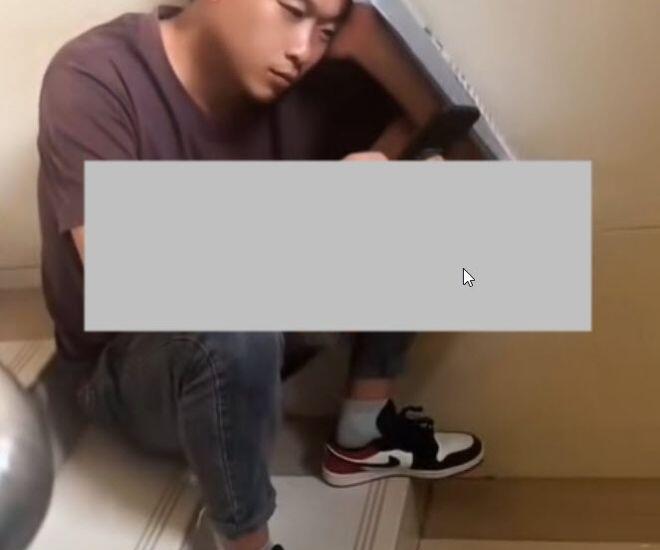 Người đàn ông buồn bã ngồi bệt ở chân cầu thang.