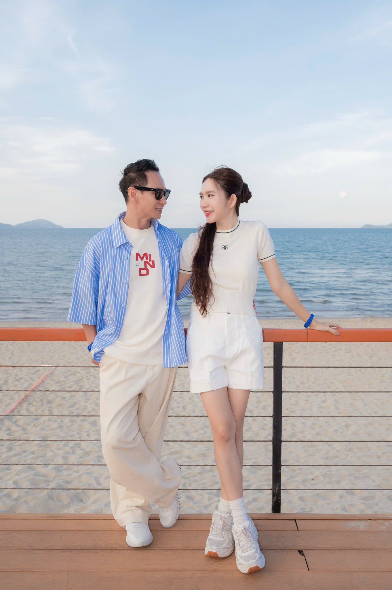 Minh Hà diện đồ bơi chuyên dụng dài tay kín đáo, hoặc là những set đồ kết hợp áo thun và quần short kèm giày thể thao để dạo biển cùng ông xã.