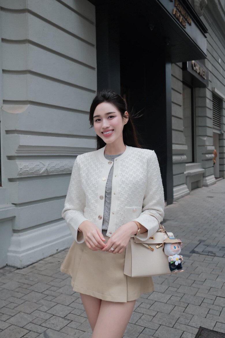 Đỗ Thị Hà vi vu Hong Kong. Người đẹp mix đồ theo phong cách tiểu thư khoe dáng trên đường phố. Để phối cùng bộ trang phục tông trắng - be, cô chọn túi xách Hermes Kelly. Thiết kế mới được bán với giá hơn 720 triệu đồng, được nàng hậu Thanh Hoá bổ sung vào bộ sưu tập đắt đỏ. 