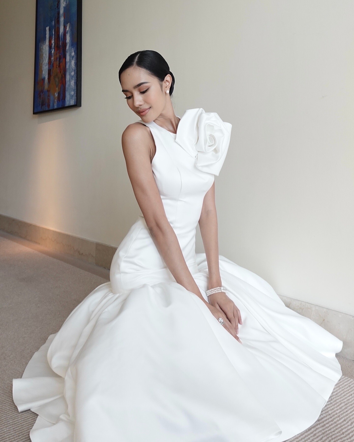 Tạm biệt những thiết kế cắt xẻ táo bạo, khoe dáng gợi cảm, lần này, Opal chọn váy trắng dài ôm sát, chất liệu trơn cao cấp với chi tiết lệch vai độc đáo, cùng tà vải đổ dài mang vẻ đẹp pha trộn giữa cổ điển và hiện đại.
