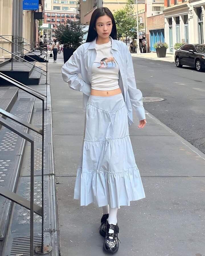 Thỉnh thoảng, Jennie thay đổi quần bằng các mẫu chân váy xòe nhẹ hoặc váy midi bay bổng để tăng độ nữ tính và mềm mại đậm chất em gái nhà bên.