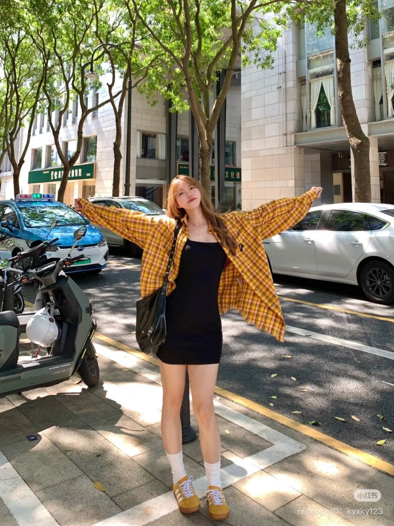 Mặc đầm đen đơn giản, chỉ cần phối ngoài cùng chiếc sơ mi kẻ ô mang sắc vàng nổi bật là đã đủ giúp bạn có tổng thể thật thời thượng và sành điệu.