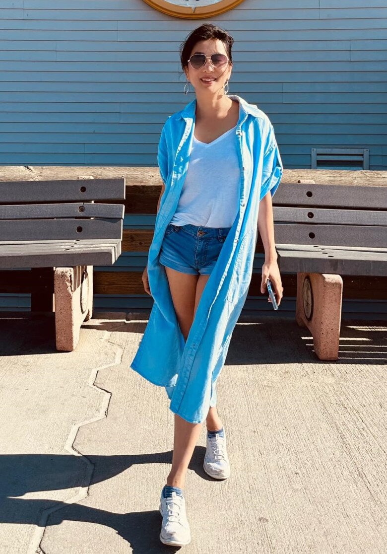 Với set đồ năng động gồm áo thun trắng, quần short jeans và áo khoác sơ mi dáng dài màu xanh, MC nổi tiếng khiến người hâm mộ bất ngờ bởi vẻ ngoài trẻ trung vượt thời gian.