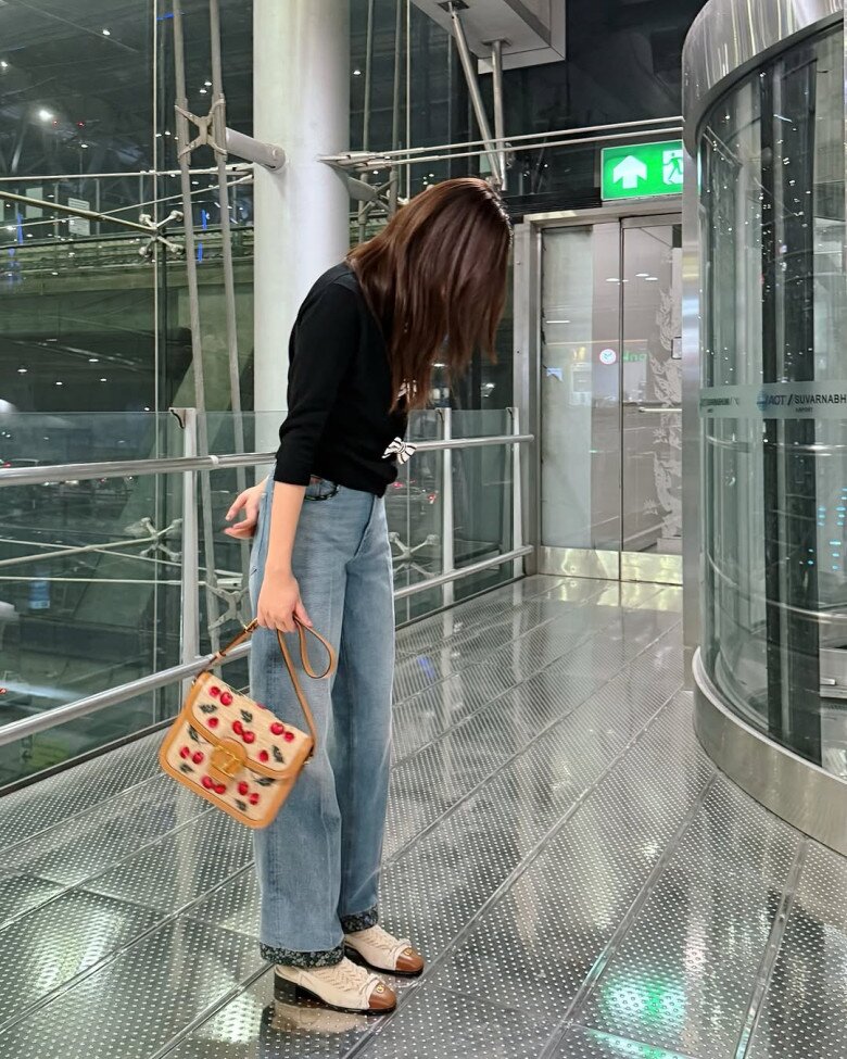 Thời trang sân bay ấn tượng của Freen với mẫu quần jeans ống suông và áo kiểu đính nơ, kết hợp cùng mẫu túi vừa ra mắt của thương hiệu Valentino mà cô nàng là đại sứ. 