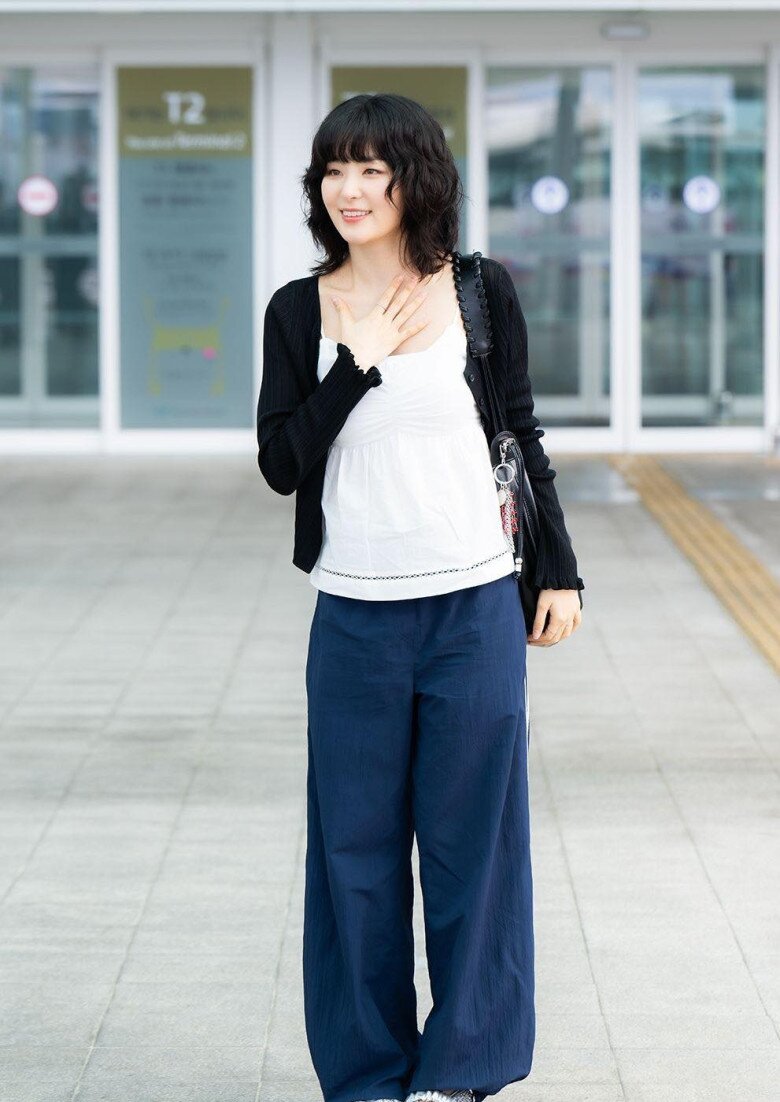 Cô nàng kết hợp áo dây với quần ống rộng và áo cardigan, phối thêm phụ kiện là túi xách da, một bộ trang phục thoải mái đậm chất mùa hè