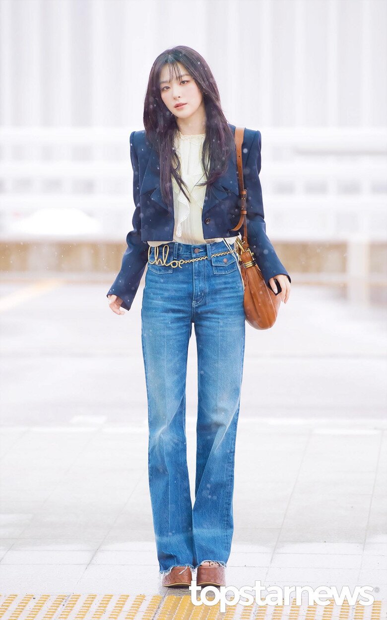 Chỉ với một chiếc quần jeans cạp cao, áo blouse bên trong và áo khoác bên ngoài, Seulgi cũng tạo được sự chú ý nhờ bộ phối quá đỗi điện ảnh và nhan sắc đẹp ngời ngời giữa trời tuyết rơi