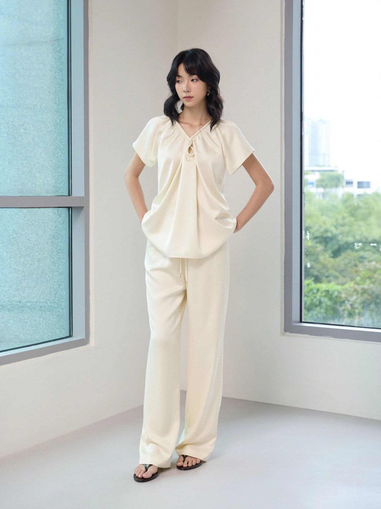 Quần lụa trắng mát mẻ, sang trọng khi diện cùng sandal đế bằng trông thoải mái mà không kém phần thanh lịch.